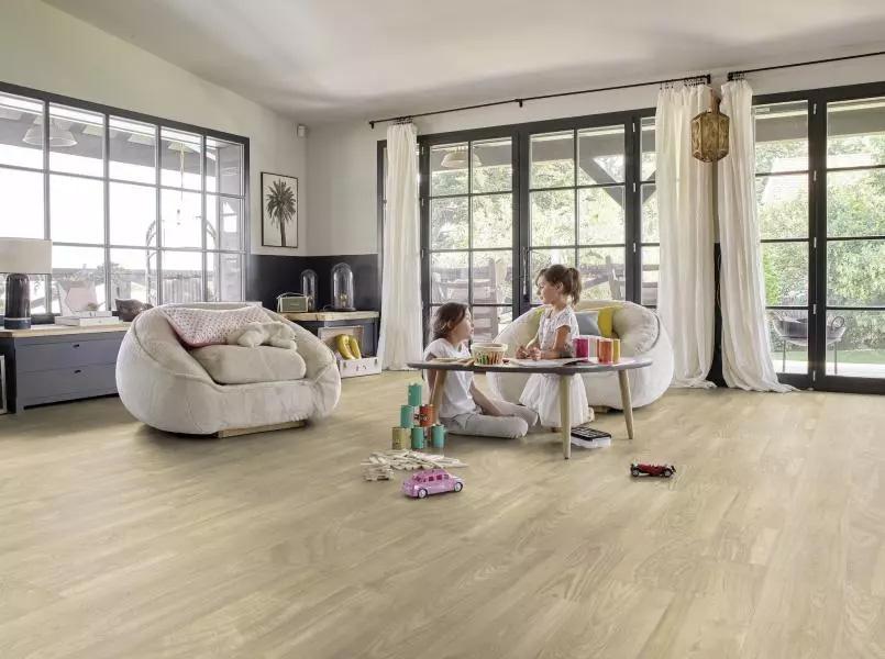 two children sitting on the floor behind a small table in the living room