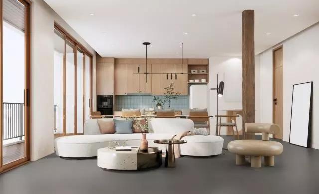 a large room with a lounge area in the front and a kitchen in the background. White walls and wooden kitchen fronts.